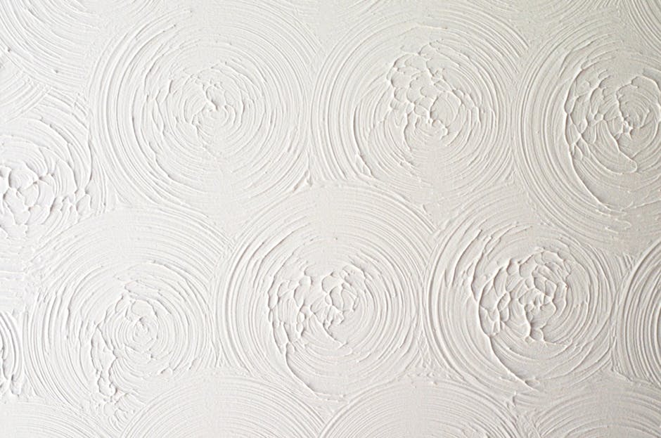 Close-up of a white plaster wall with spiral texture, ideal for backgrounds or design projects.
