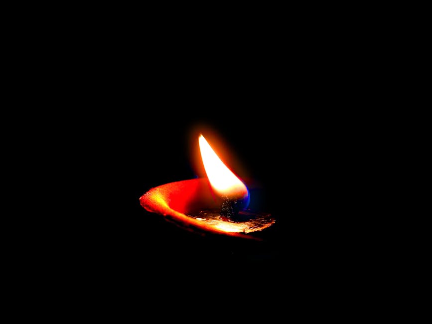 A vibrant candle flame illuminating the dark, symbolizing hope and peace.