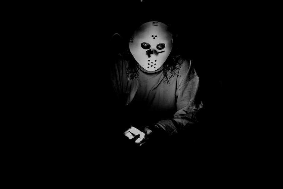A mysterious figure wearing a mask, illuminated in low light, creating a spooky ambiance.