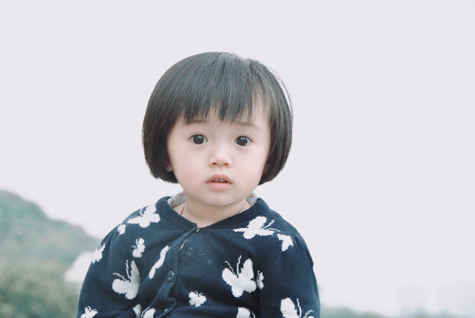Cute child in a warm sweater outdoors, showcasing innocence and curiosity in a serene setting.