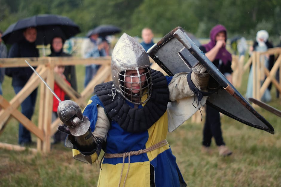 A knight in full armor engaged in a lively medieval reenactment outdoors.